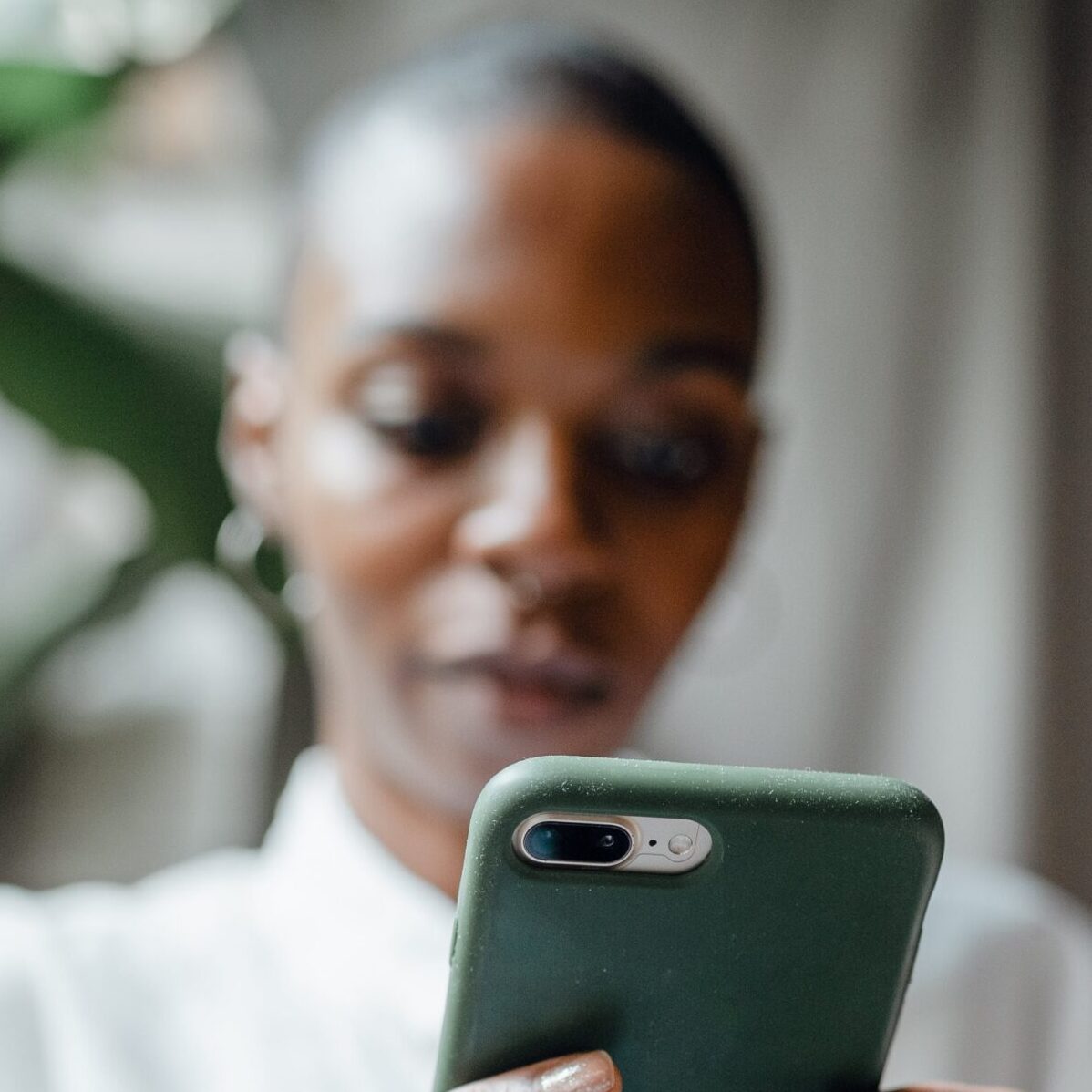 Person looking down at a mobile phone.